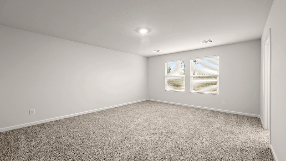 Large primary bedroom with dual windows and opening to en suite