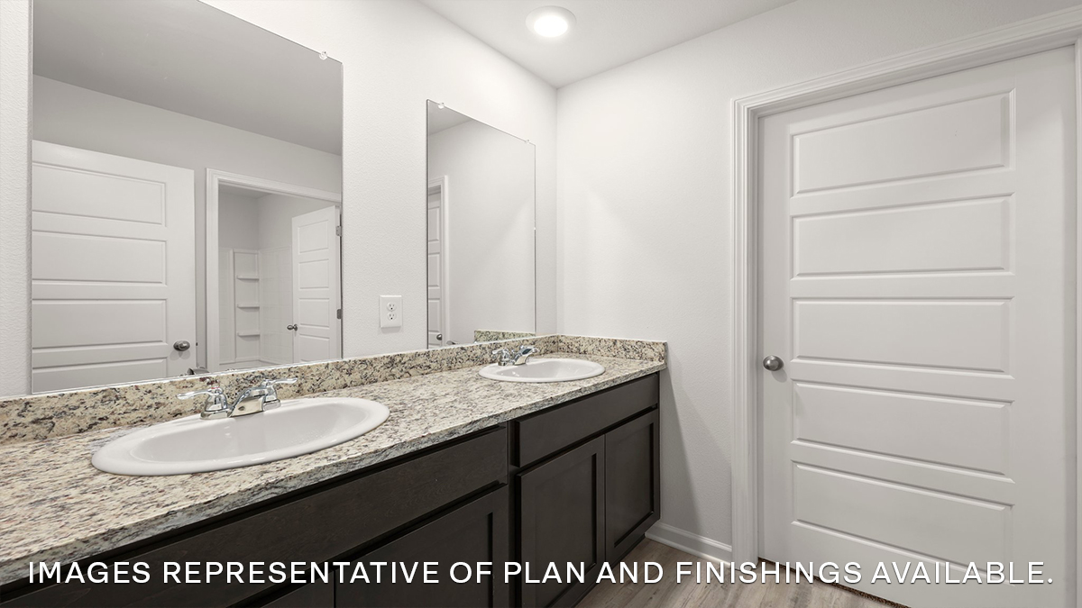 Dual vanities in primary bath with door to shower tub combo and toilet