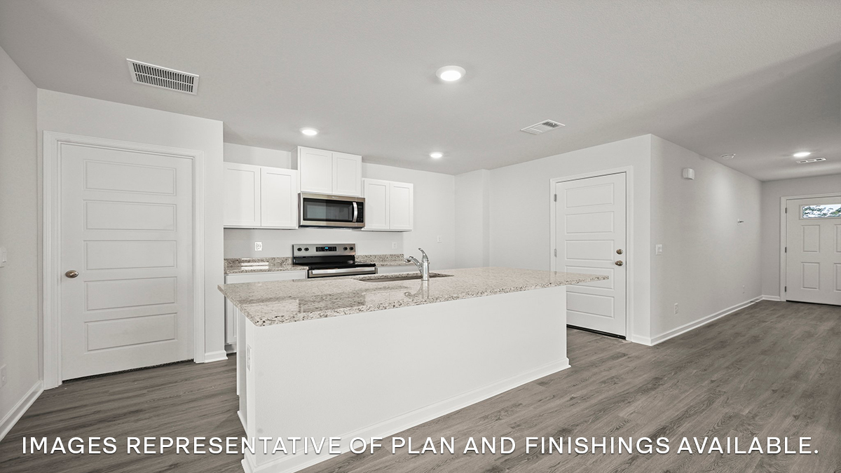 White kitchen island and foyer with access to front of home