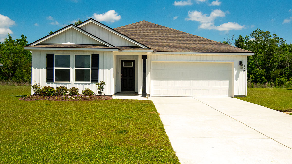 single-story home with white vinyl siding and black front door and shutters with two-car garage