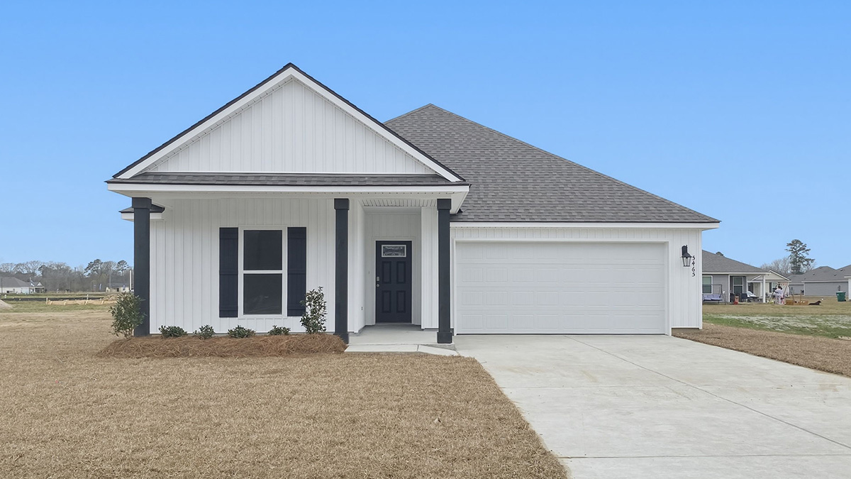single-story home with white vinyl siding and black front door and shutters with large porch and two-car garage