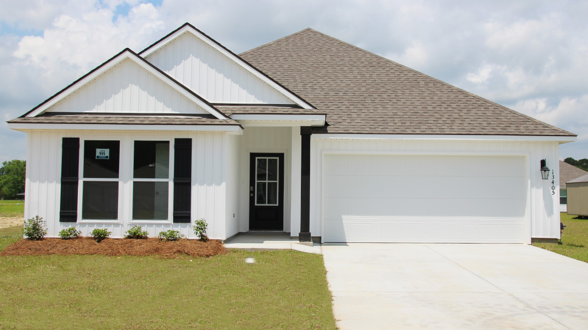 Single-story home with white vinyl. Black glass front door with black shutters and white trim.