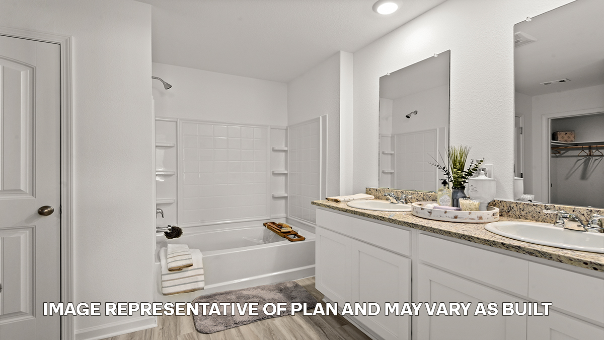 primary bathroom with dual vanities, mirror and shower tub combo