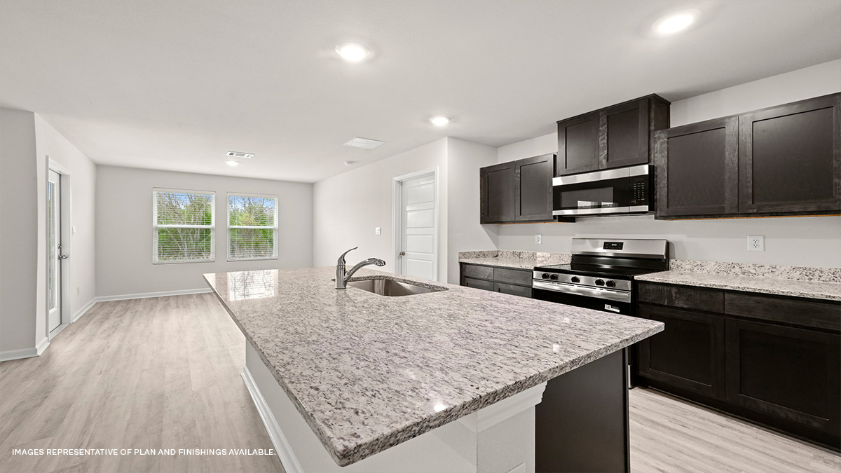 Dark grey kitchen cabinets and island with stainless steel appliances and foyer access