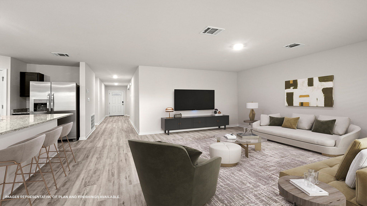 Rear view of open-concept living space with kitchen island and stainless steel appliances with foyer