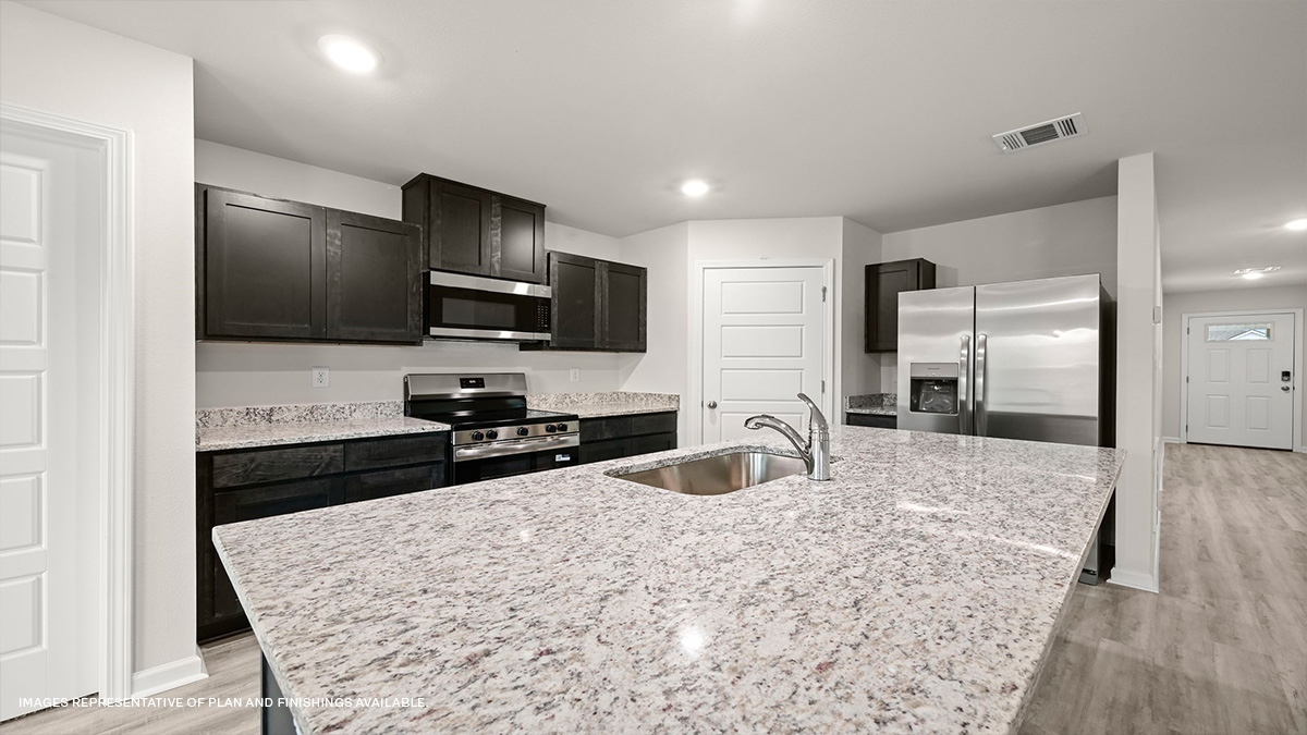 Dark grey kitchen cabinets and island with stainless steel appliances and pantry access