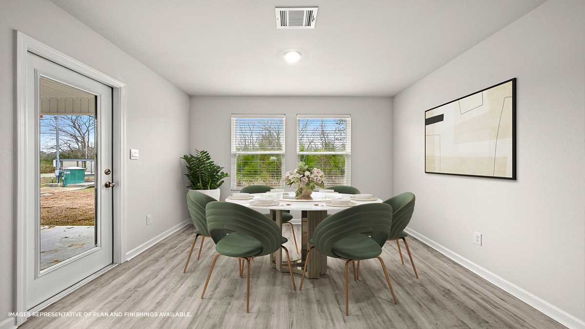 Rear view of open-concept living space with kitchen island and stainless steel appliances with foyer