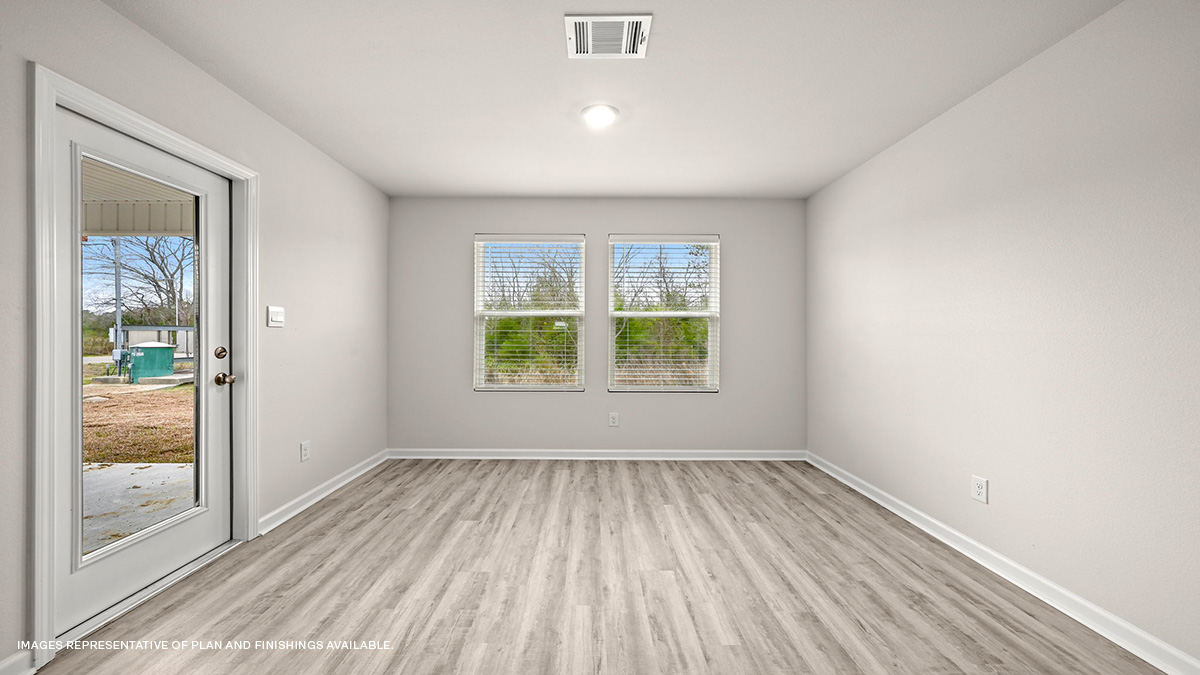 Rear view of open-concept living space with kitchen island and stainless steel appliances with foyer
