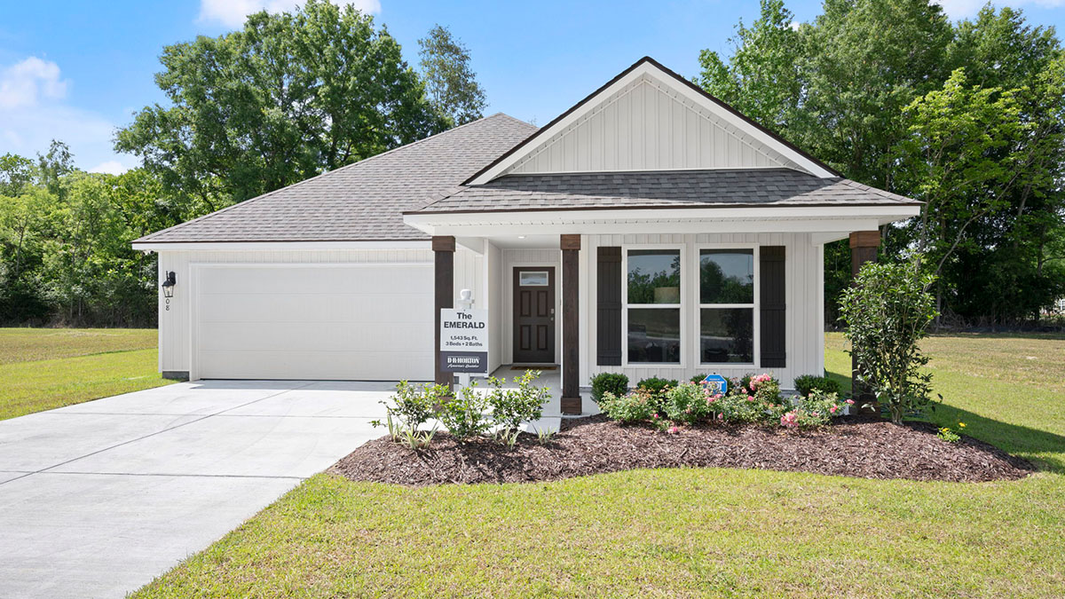 single-story home with white vinyl and black front door and shutters with two-car garage