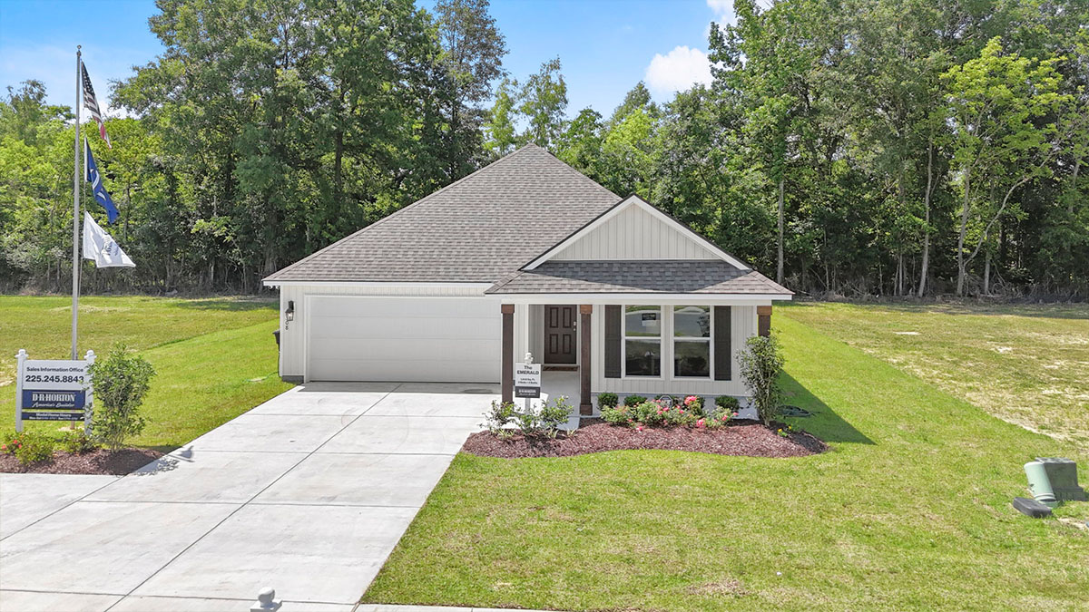 single-story home with white vinyl and black front door and shutters with two-car garage