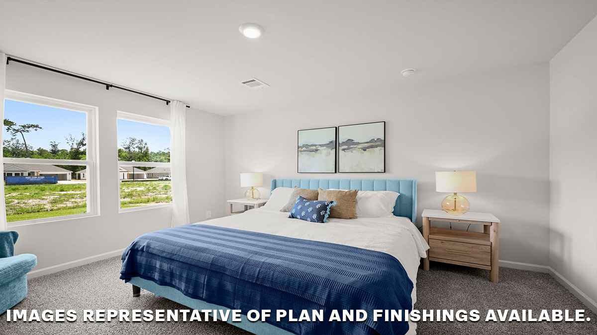 Large primary bedroom with dual windows overlooking the backyard