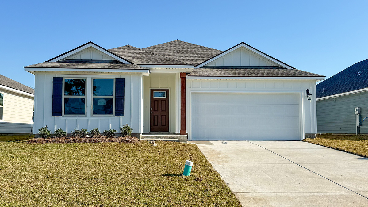 single-story home with white vinyl siding and black front door and brown shutters with two-car garage