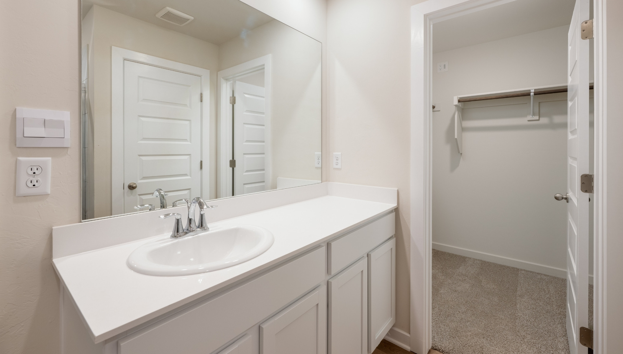 primary bathroom with single vanity and walk in closet