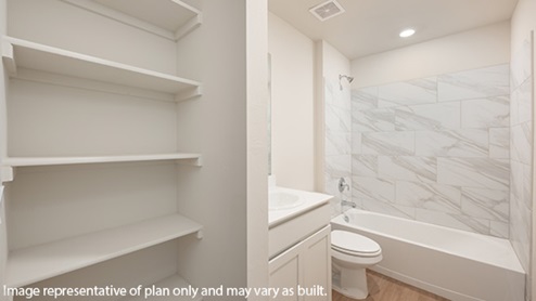 Secondary bathroom with quartz countertops and full tile surround