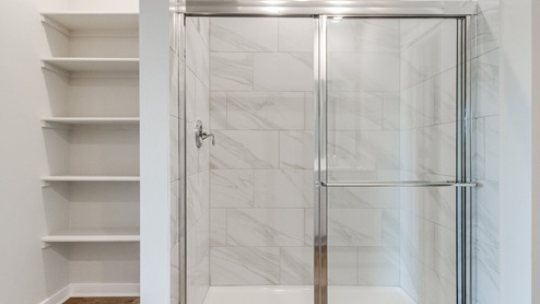 primary bathroom with shower and shelves