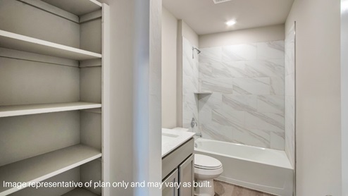 Large secondary bathroom with walk in shower with tile surround