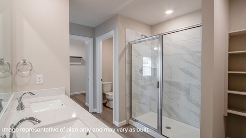 Large primary bathroom with walk in shower with tile surround