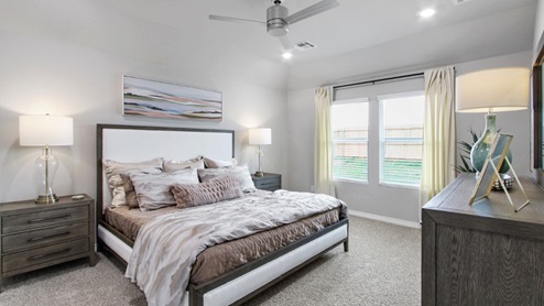 primary bedroom with window and fan