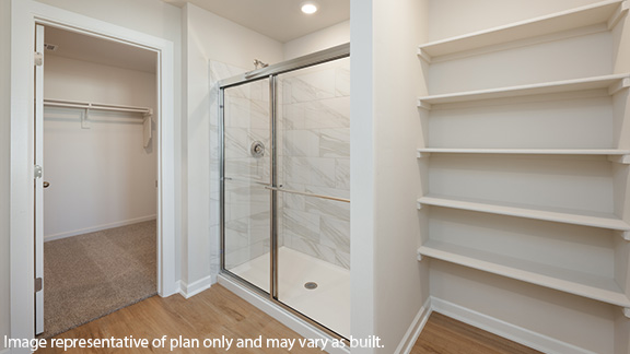 Primary bathroom with enclosed shower and shelving