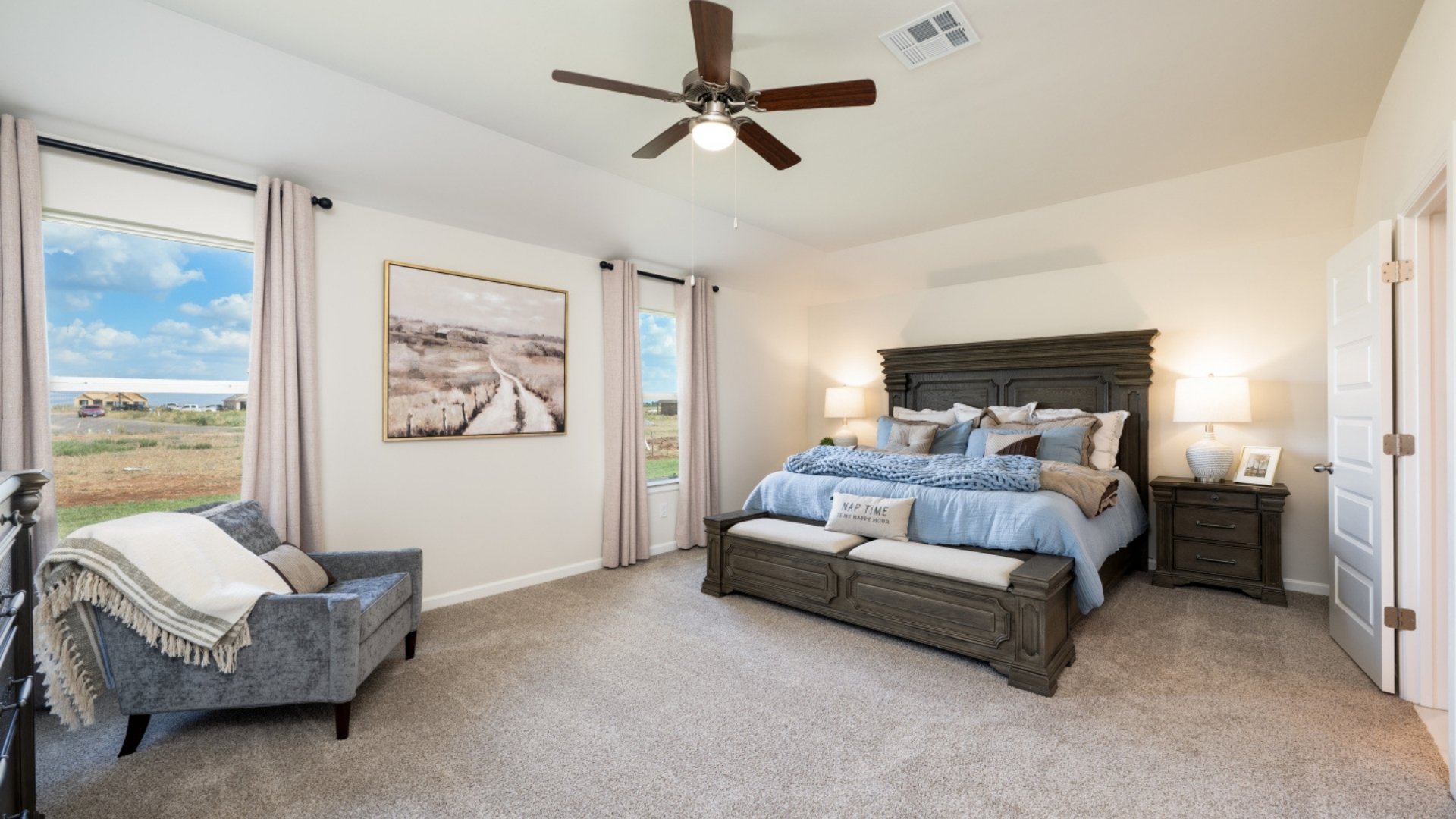 primary bedroom with windows and ceiling fan