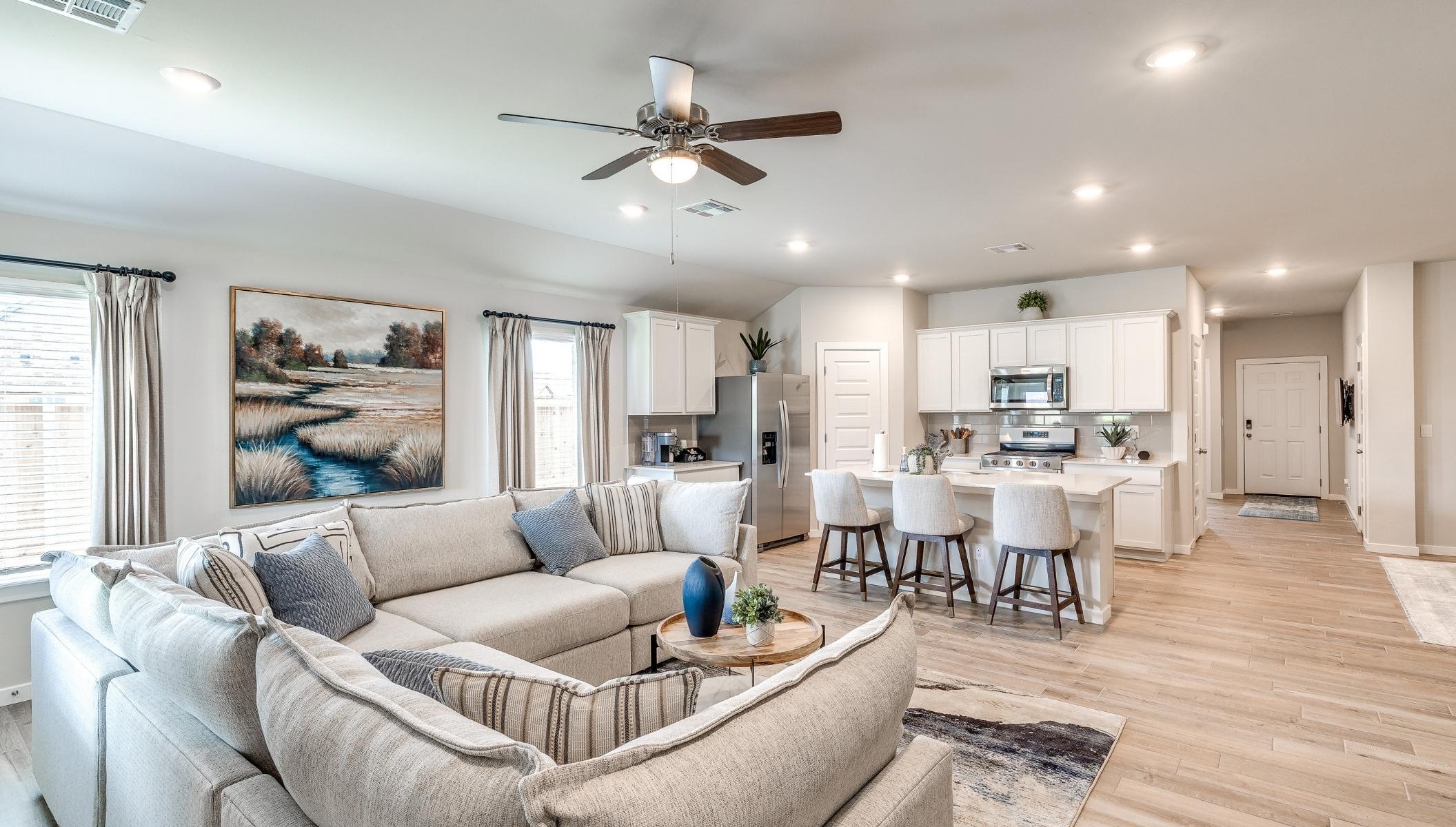 living room with fan opening to kitchen island in Norman, Oklahoma