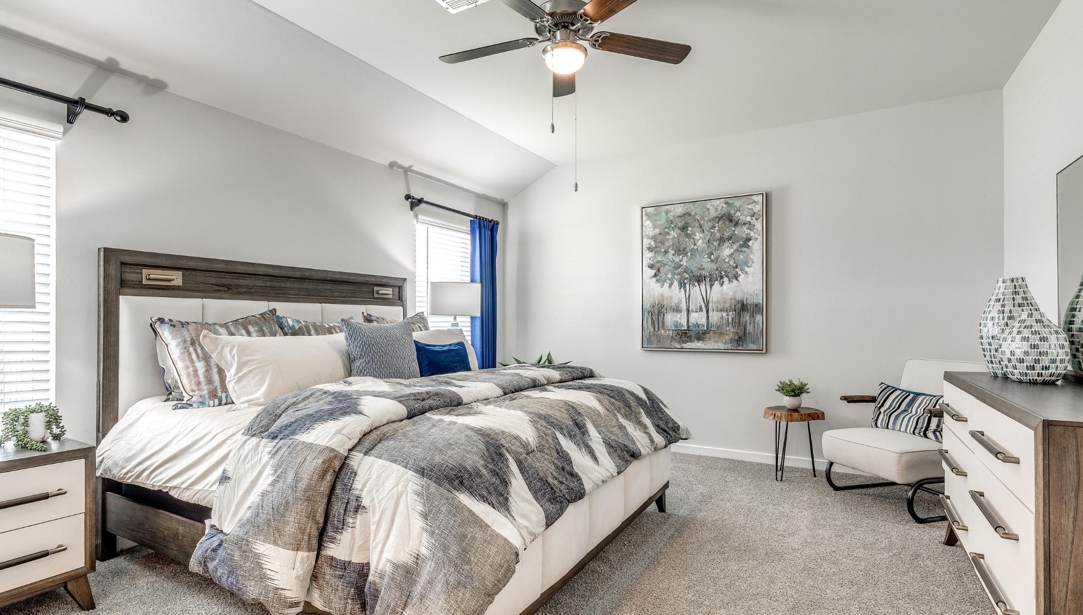 primary suite with windows and ceiling fan