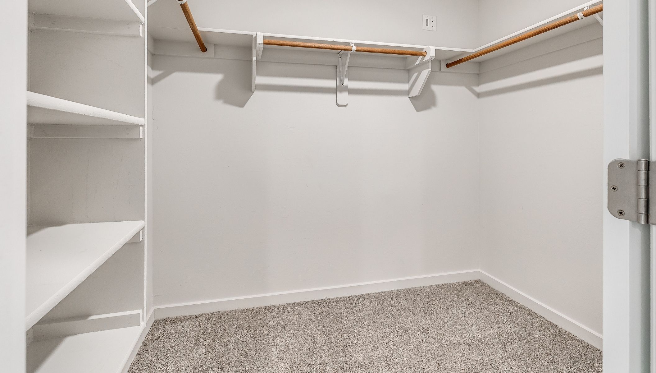 primary ensuite with large walk-in closet with shelves, and hanging rods