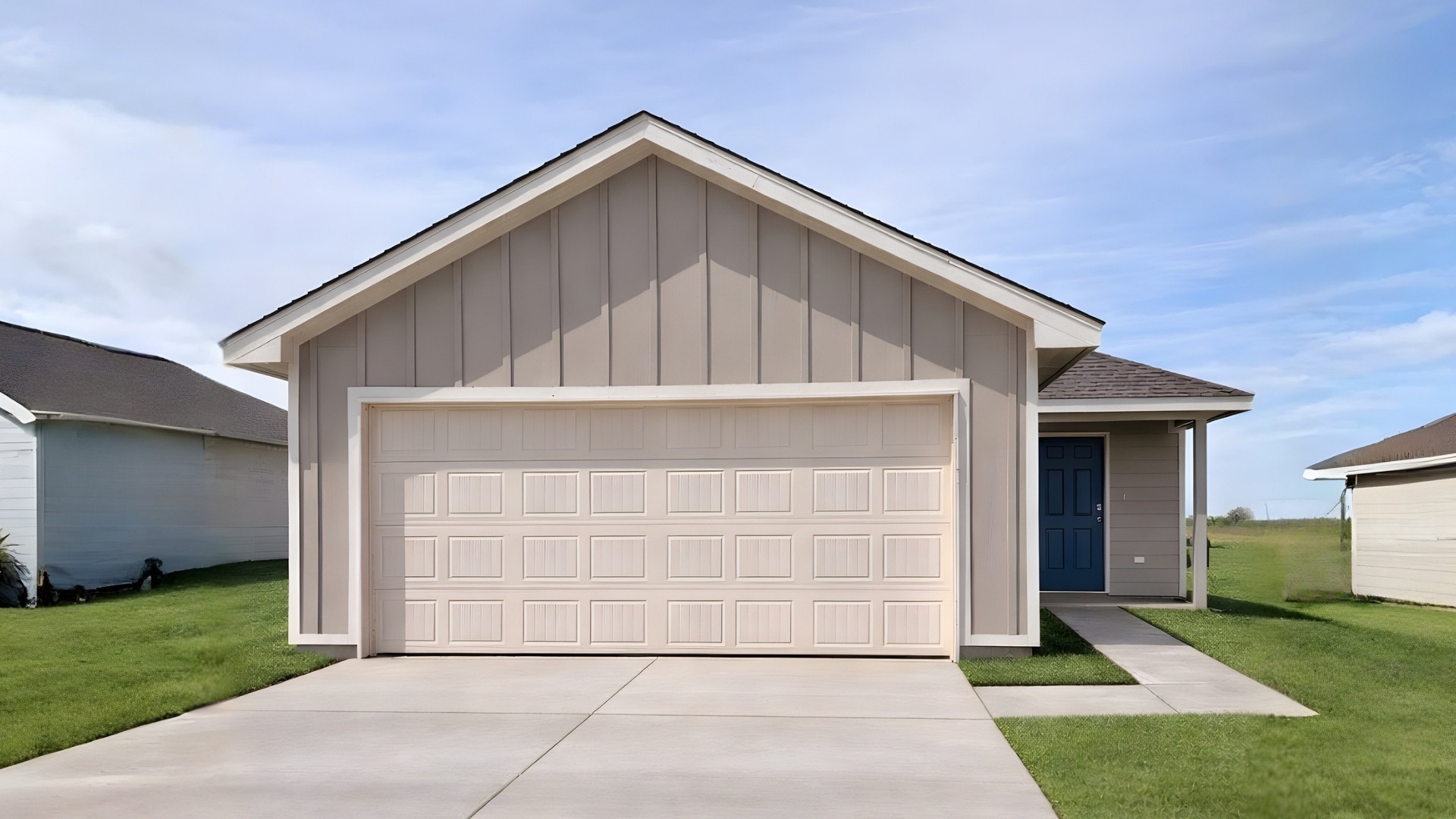 View of front facade with board and batten siding, driveway, and roof with shingles