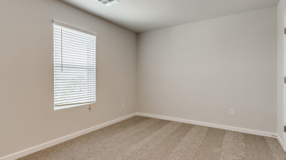 Empty room featuring light colored carpet and baseboards