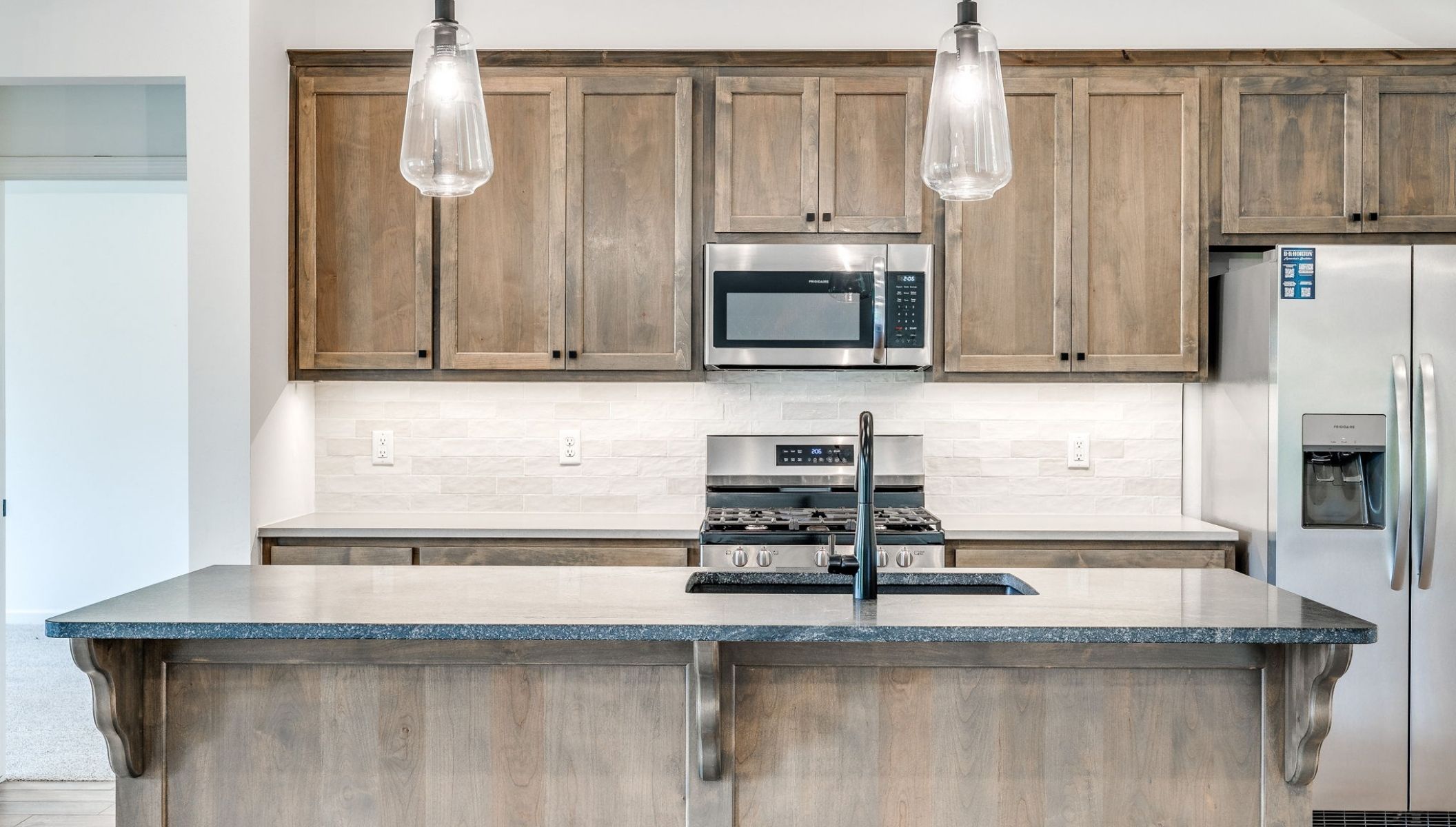 kitchen island with lights and stained cabinets