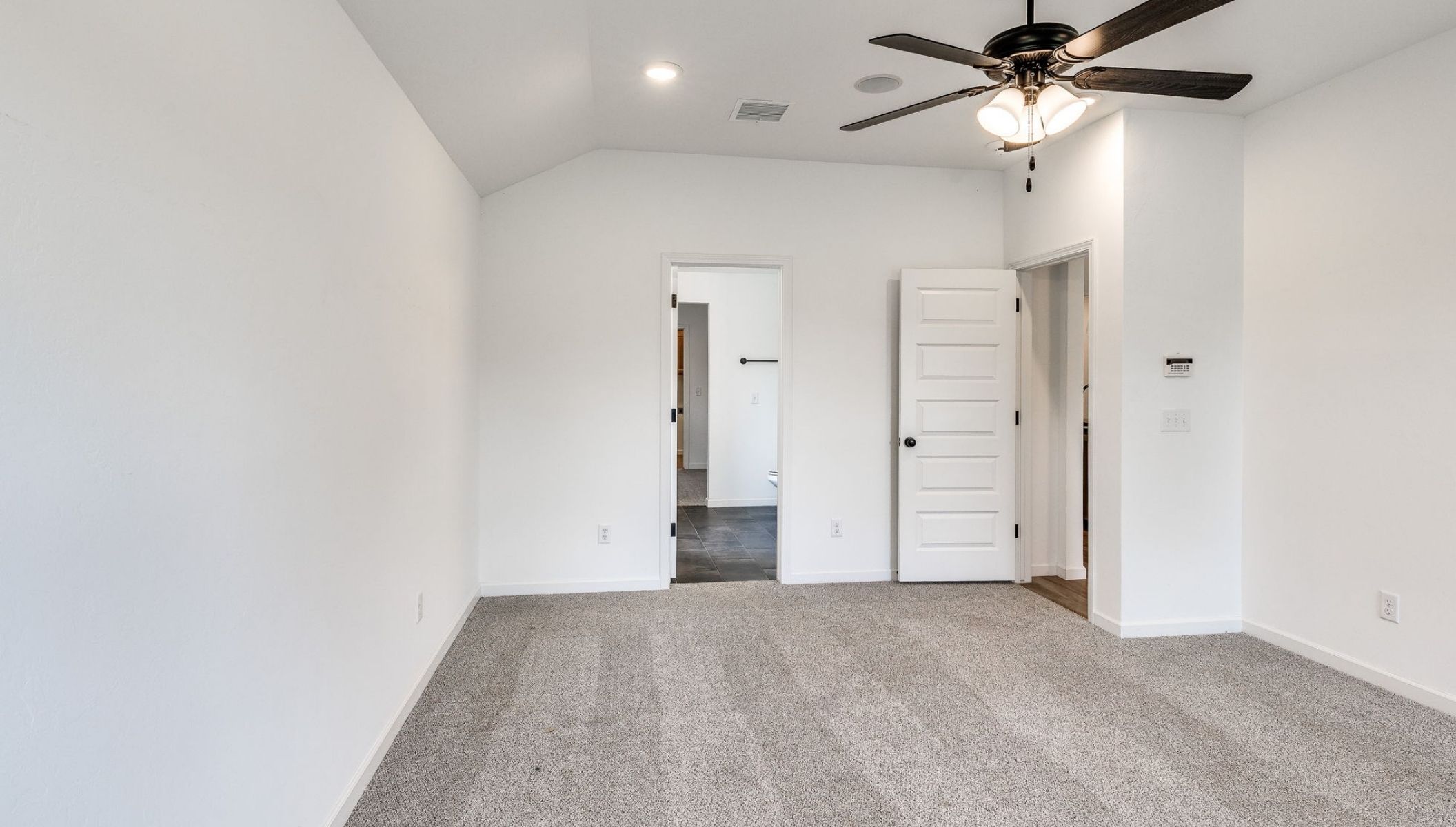 primary bedroom with fan and two windows