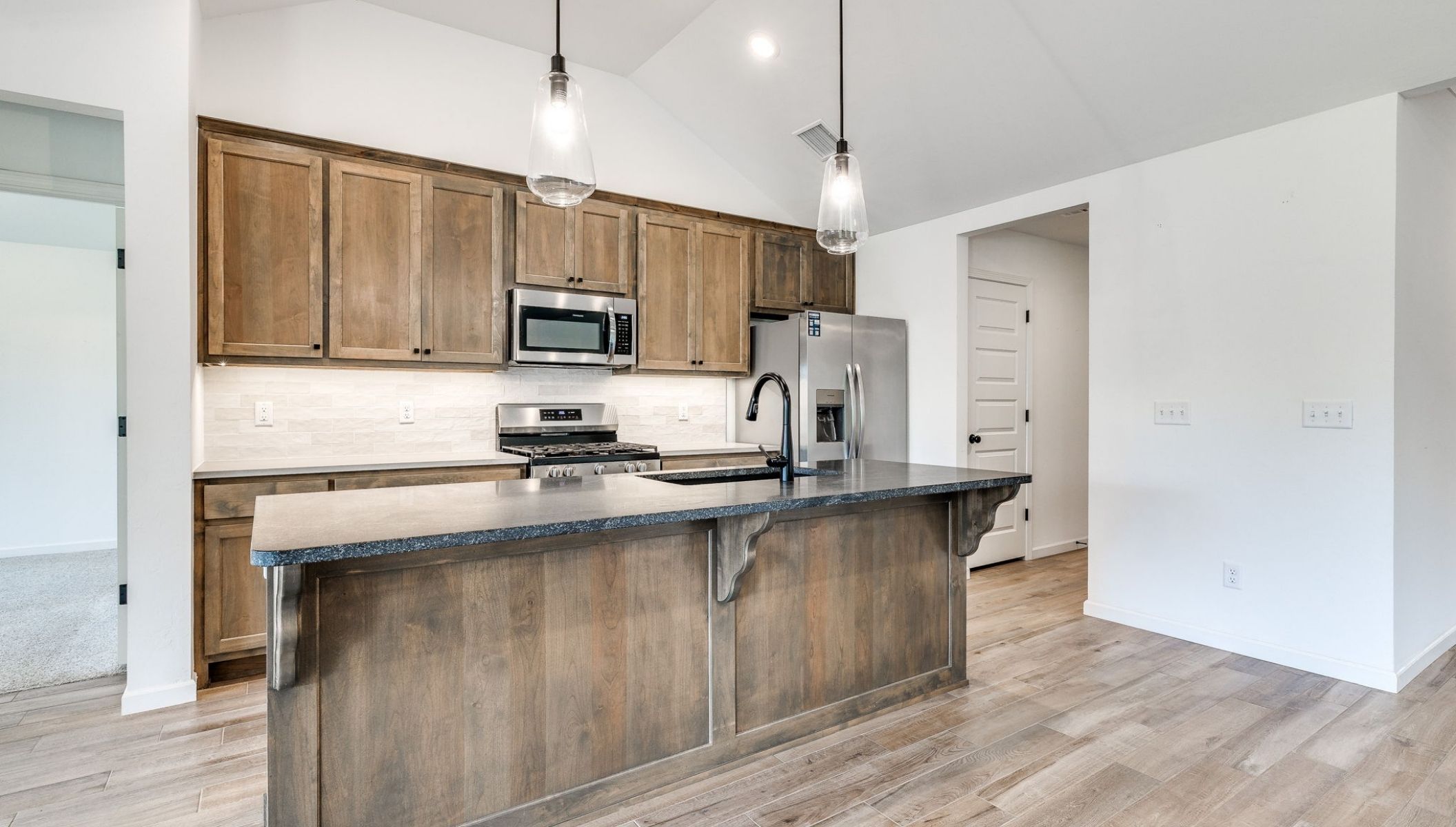 kitchen island with lights and stained cabinets