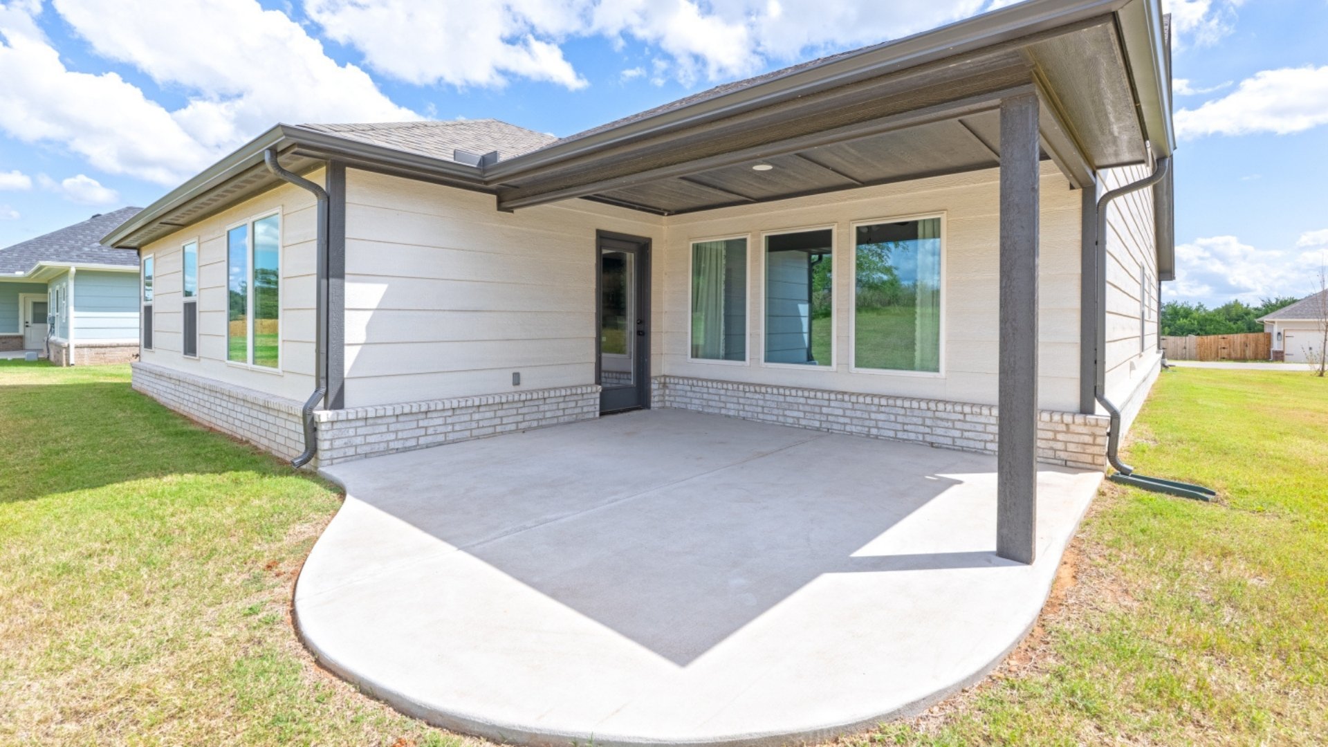 Back exterior of home with round cement patio.