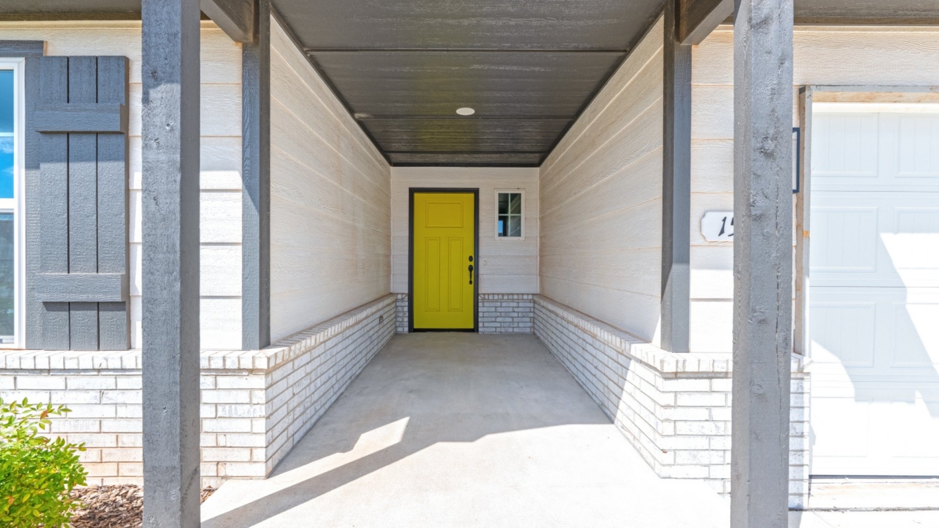 Front exterior entryway with yellow front door.