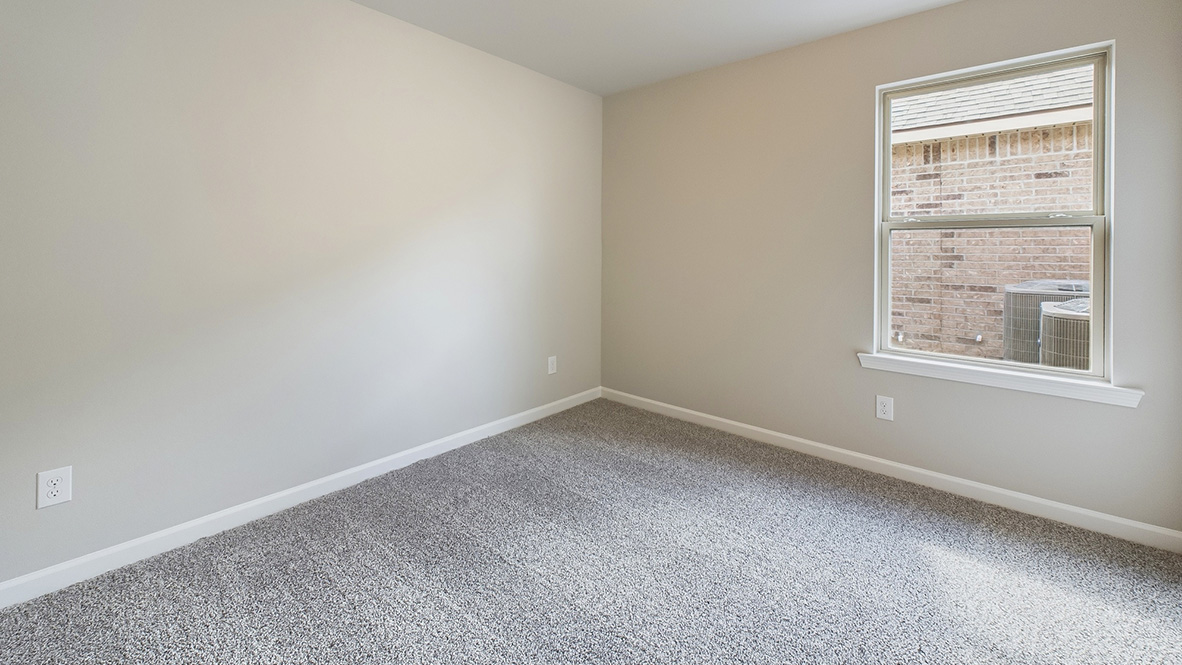 bedroom with beige carpet, beige walls and a window