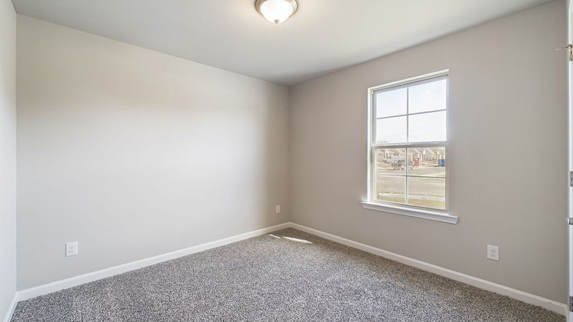 Second bedroom in Coteau Ridge  showcases quality designs with closet space, soft window light, upstairs connectivity