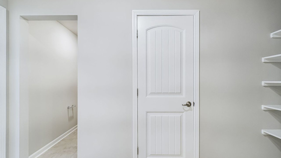 The single story Catahoula home plan bathroom has modern fixtures, closet space and granite countertops.