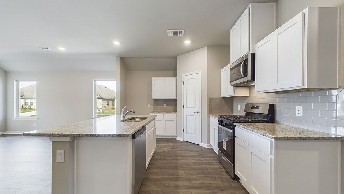 The single story Lakeview home plan has a spacious kitchen and island with granite countertops.