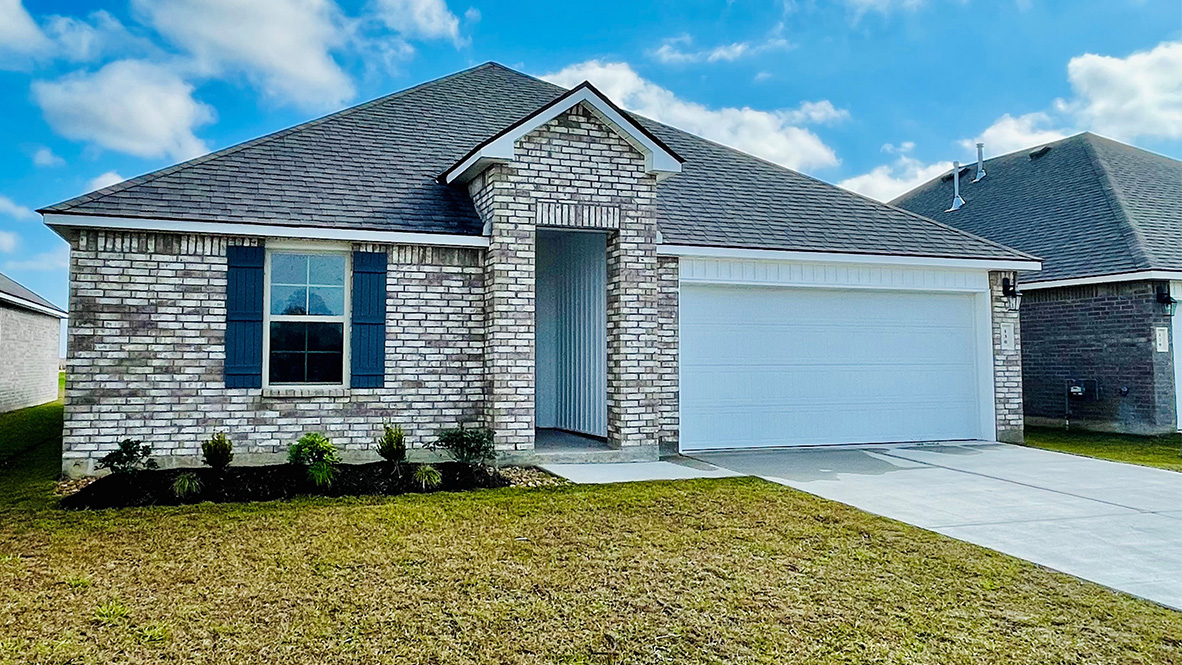 front exterior of a home with brown stone exterior and a two car garage