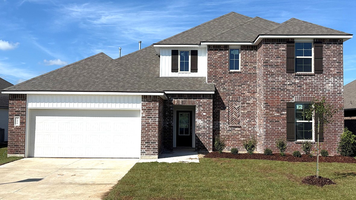 Two story home with stone details and clean landscaping.