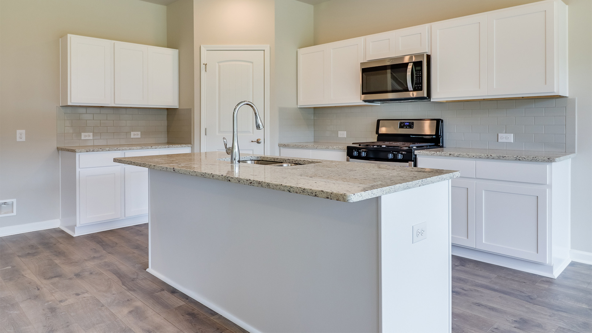 Kitchen featuring brand new stainless steel appliances, cabinets, and a large island.