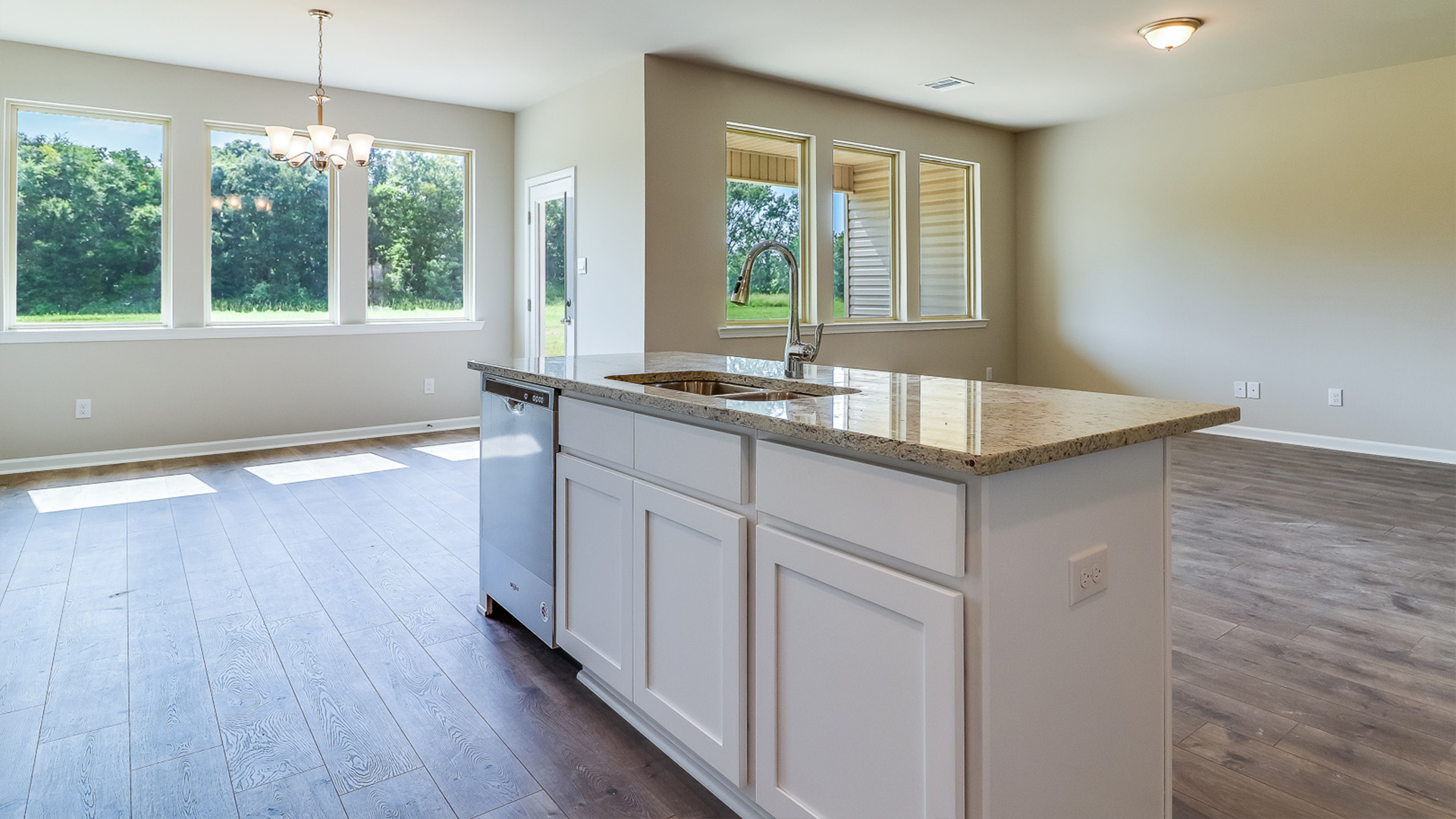 Open concept kitchen area connecting to living and dining space.