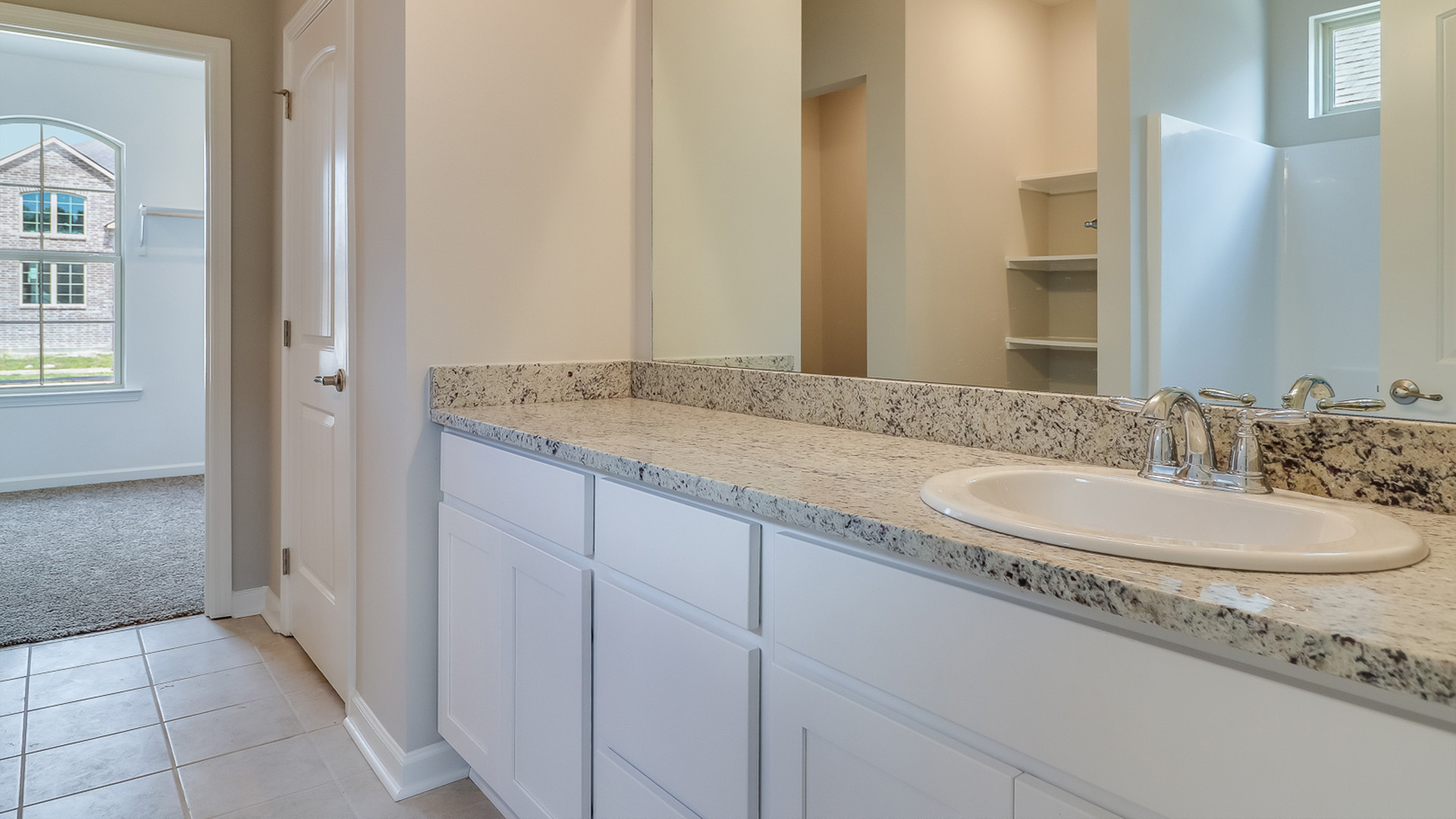 Bathroom with dual sinks and a wide mirror.