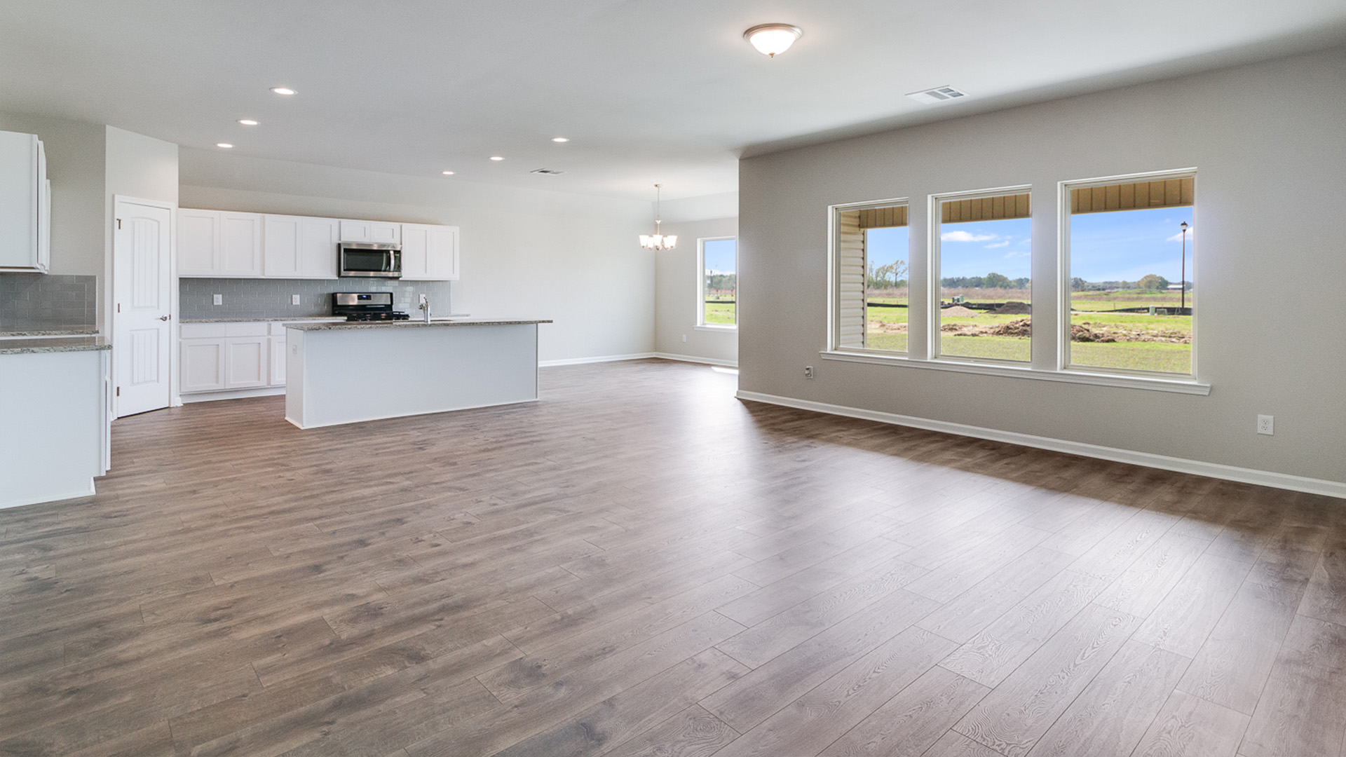 Dining room looking toward modern kitchen island, next to backyard, new appliance suite included at Magnolia Lakes