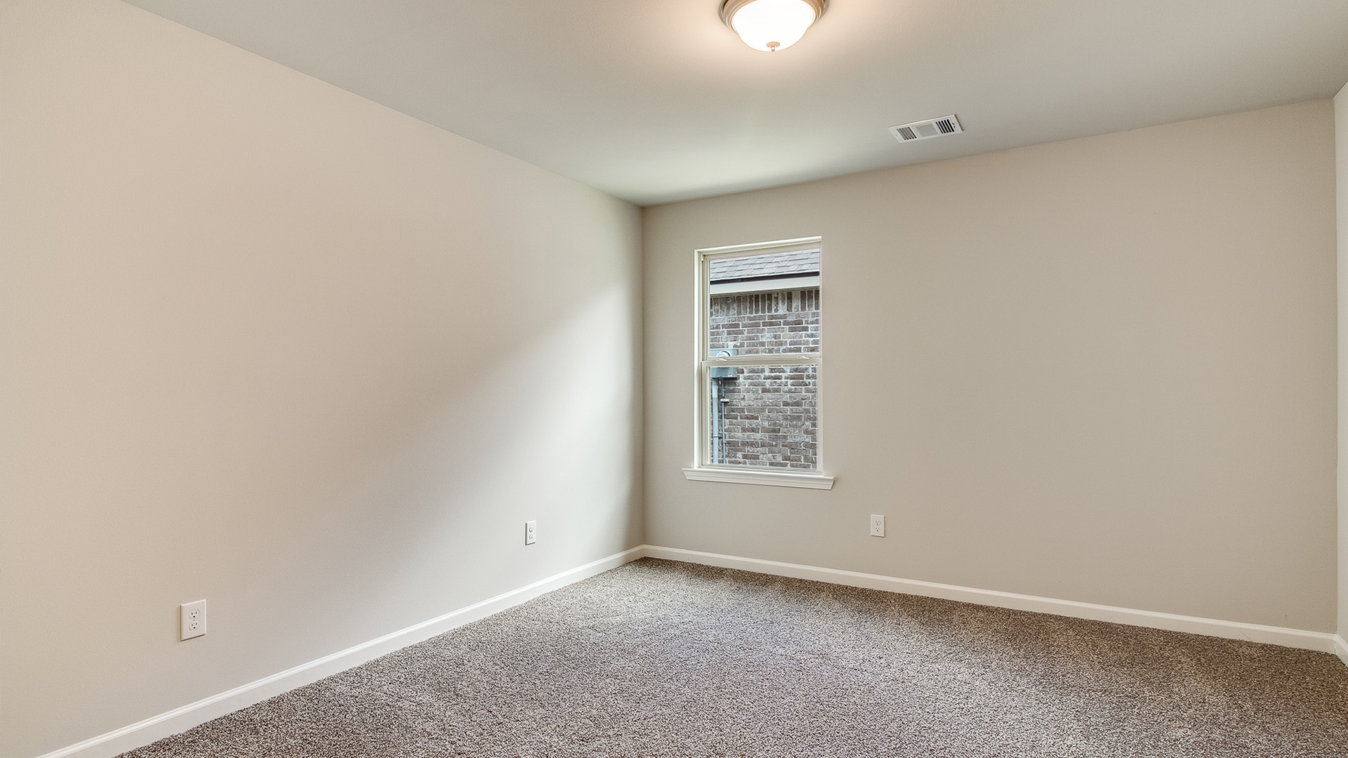 Bedroom with neutral walls, carpet, and a window.