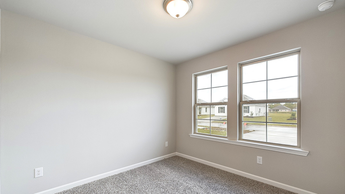bedroom with beige carpet, beige walls and a window