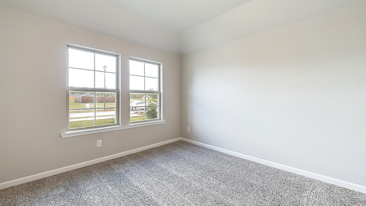 bedroom with beige carpet, beige walls and a window