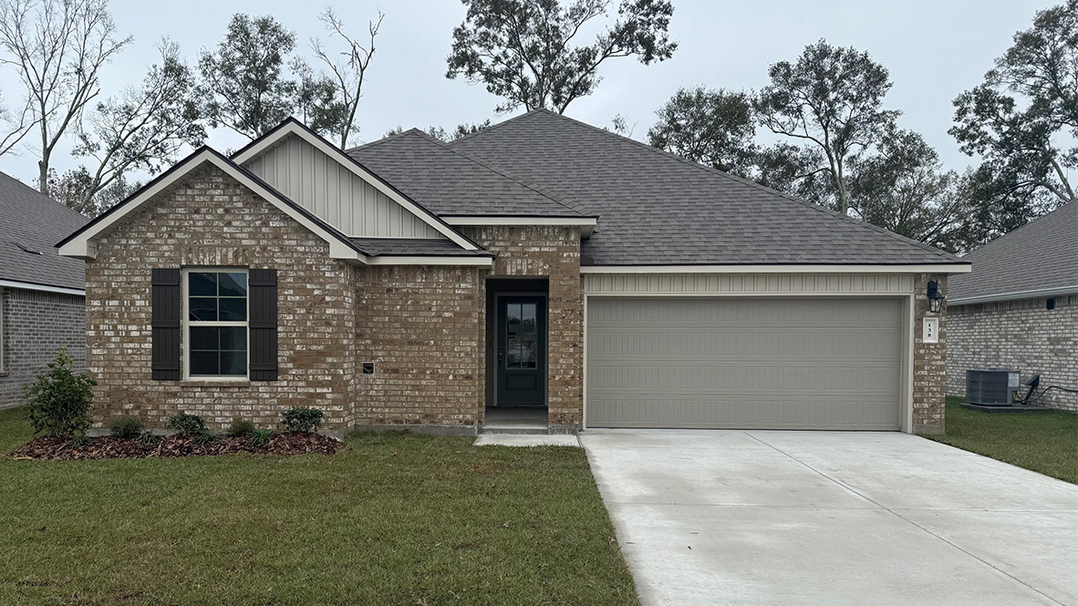 One story home with two car garage and paved driveway.