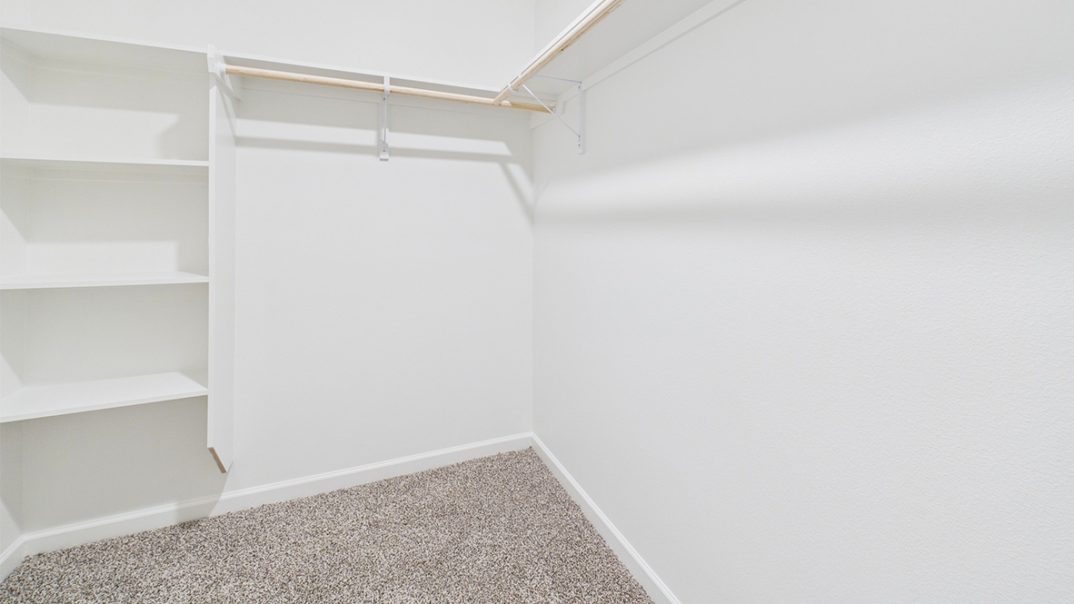 Interior view of walk-in closet in the primary bedroom and spa-inspired ensuite in Hollis Heights, a new home by D.R. Horton