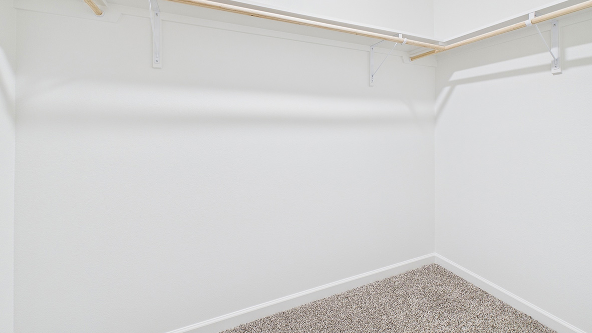 Primary suite walk-in closet in Hollis Heights  new home with built-in shelving and generous storage